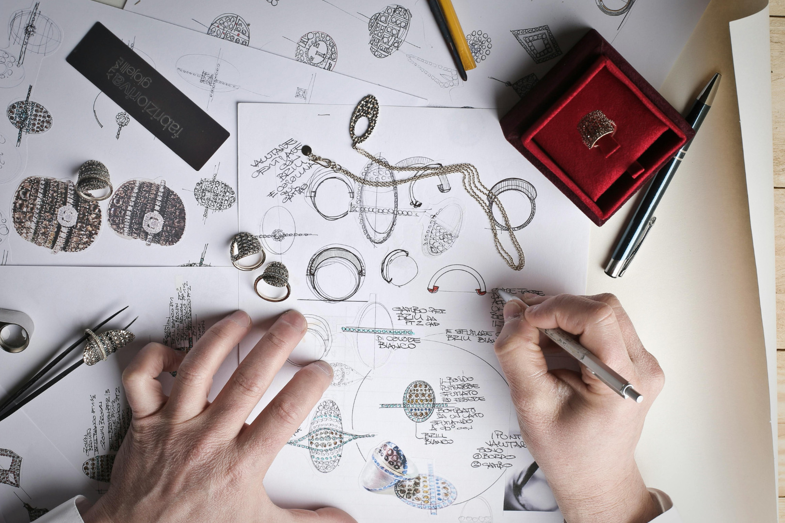 Jewelry designer sketching custom jewelry pieces on paper, showcasing 2025 jewelry trends like bold designs and intricate craftsmanship