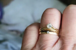 Close-up of a gold wedding ring set on a finger that may need resizing