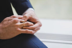 Man in a suit wearing a gold wedding band for men