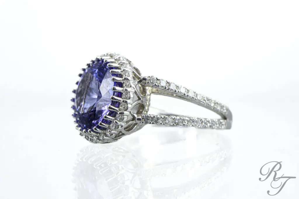 Sapphire gemstone ring surrounded by diamonds on a silver band – a unique engagement ring alternative