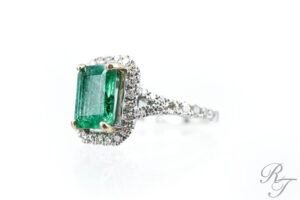 Emerald gemstone engagement ring with diamond halo