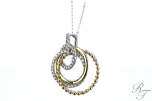 A custom necklace with interlocking circles of white and yellow gold, adorned with diamonds. This elegant design is a perfect example of a custom necklace.