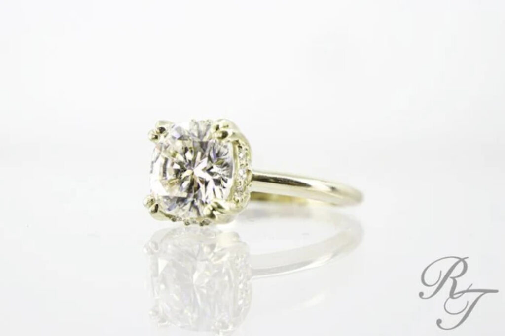 A close-up of a diamond ring's intricate setting, showing the sturdy prongs and tips that hold the main stone.