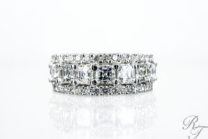 A wide, custom eternity ring featuring a center row of square-cut diamonds flanked by two rows of round pavé diamonds, representing Ethical sourcing in jewelry.