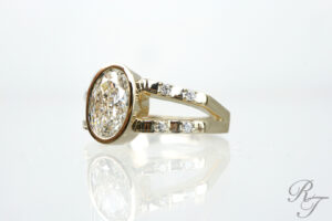 Custom gold bezel-set oval diamond engagement ring with a split-shank band, designed locally in Knoxville, TN.