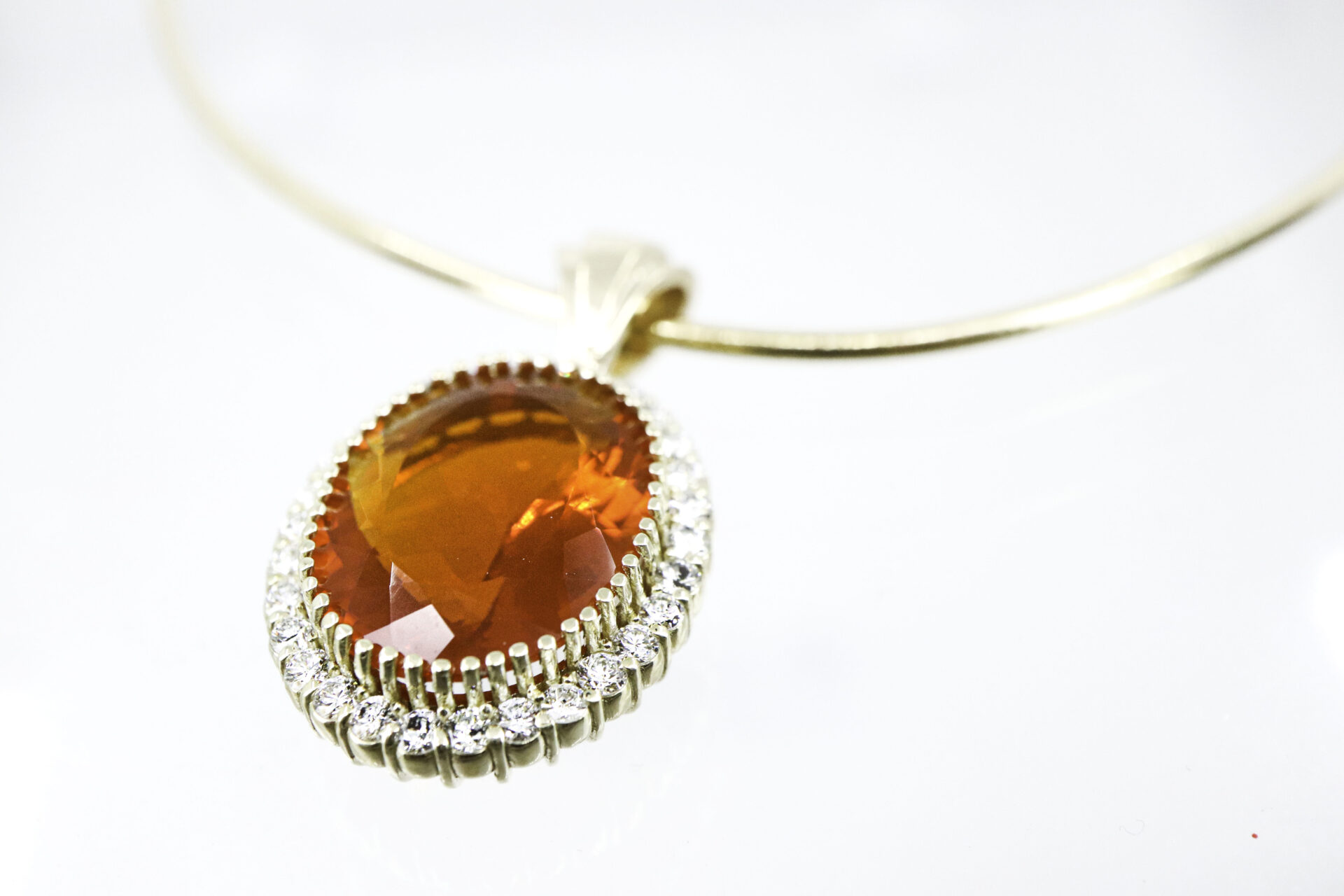 Custom pendant necklace with orange gemstone and diamond halo in gold setting
