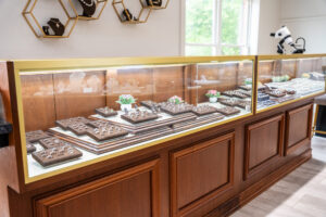 Rick Terry Jewelry Designs Showroom Display Cases Knoxville TN Custom ring display cases at Rick Terry Jewelry Designs showroom in Knoxville TN featuring gold-trimmed glass cases with rings on brown velvet trays