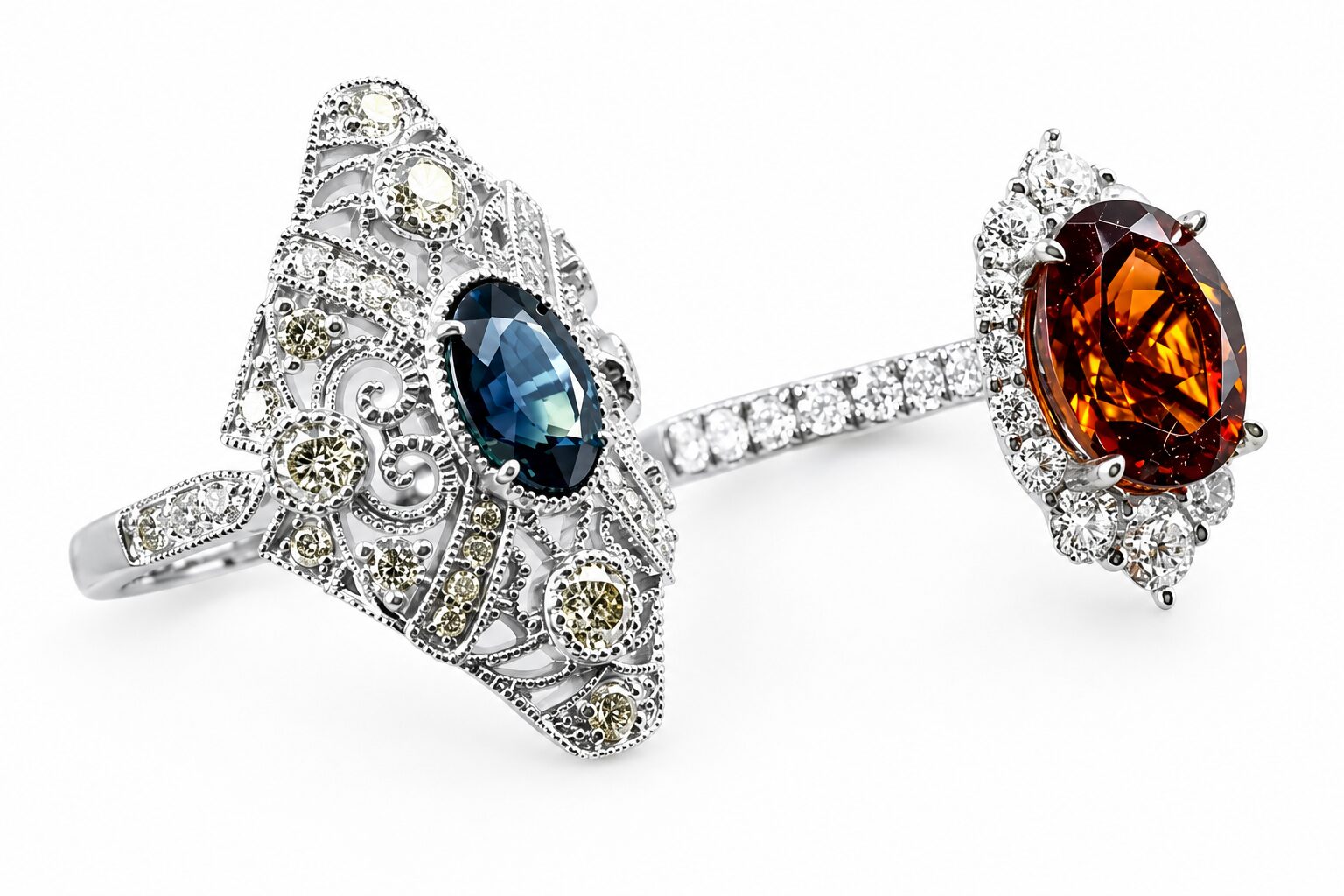 Two custom gemstone rings from Rick Terry Jewelry Designs in Knoxville, featuring a vintage filigree sapphire ring and a diamond halo garnet ring
